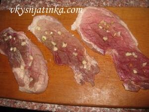 В надрезы на мясе вкладываем кусочки чеснока